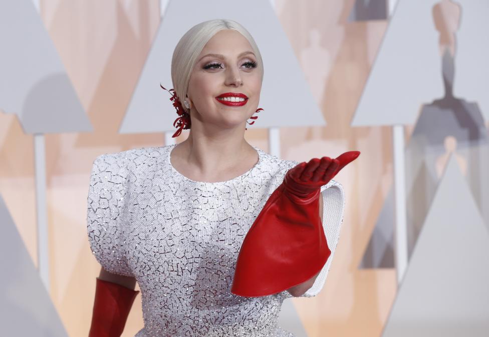 Singer Lady Gaga wears three custom-made Azzedine Alaia pieces and a white embellished gown with long red gloves as she arrives at the 87th Academy Awards in Hollywood, California February 22, 2015. REUTERS/Mario Anzuoni