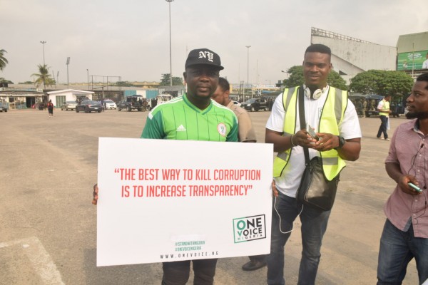 Seyi Law poses for a picture with a placard