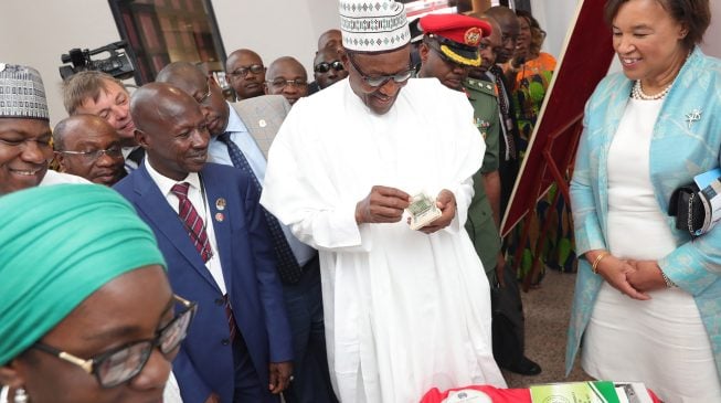 PHOTOS: Buhari counts fake dollars at new EFCC head office