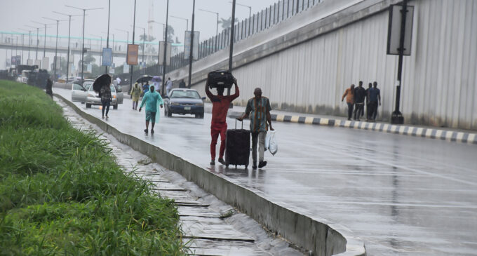 PHOTOS: Passengers walk in rain as students block roads to Lagos airport over ASUU strike