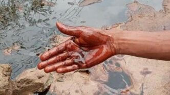 A resident scoops from the fresh oil spill in Bodo community, Rivers.