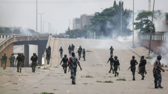 Police officers disperse protesters with teargas in Abuja during the nationwide marches against bad governance