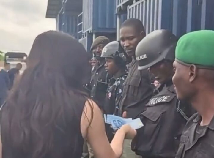 A screenshot of police officers receiving money from Chinese nationals