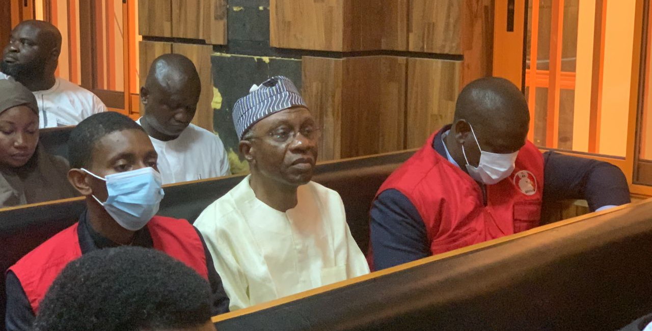 Godwin Emefiele (in white) flanked by two EFCC operatives, in court | File photo