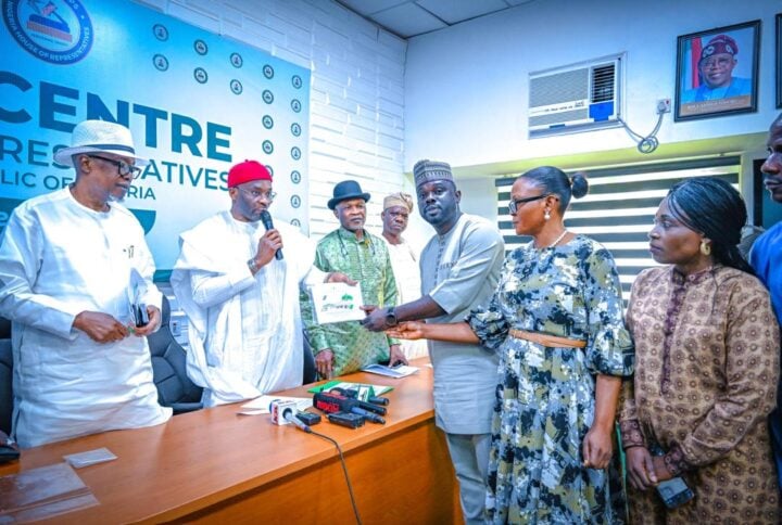 Benjamin Kalu, deputy speaker, handing over a compendium of 86 bills on constitution review to Gboyega Onadiran, chairman of the house of reps press corps