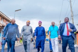 Tokunbo Abiru in blue outfit (middle)
