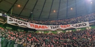 Fans with a banner calling for the ban of Israel from football over the country's war on Gaza